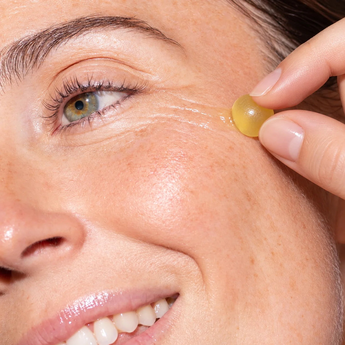 Applying a LIFT Jelly Peptide serum shot sphere directly onto the face. IOKURO